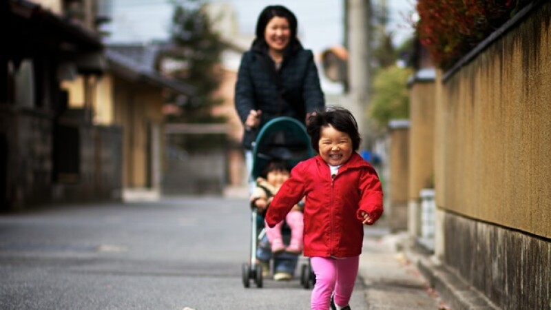 una madre asiatica pasea a sus hijos