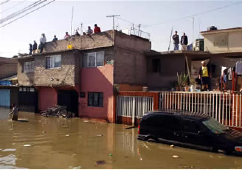 Habitantes de El Arenal se refugian en las azoteas mientras esperan que comience el desazolve del agua. (Foto: Notimex)