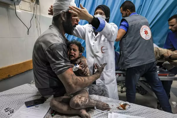 Un hombre sostiene a un niño, sobrevivientes de los bombardeos israelíes, mientras son tratados en una sala de trauma en el hospital Nasser en Khan Yunis, en el sur de la Franja de Gaza, el 24 de octubre de 2023 en medio de las batallas en curso entre Israel y el grupo palestino Hamas.