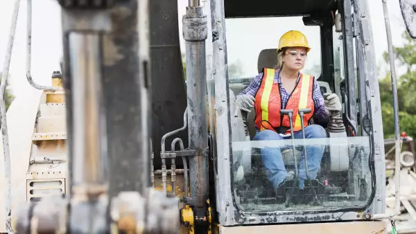 Hispanic female construction worker driving earth mover
