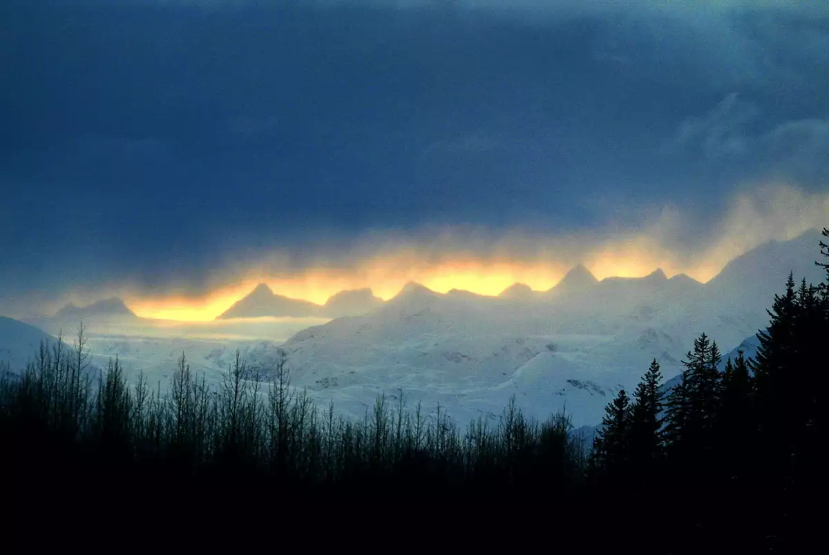 Las nubes se ciernen sobre los picos nevados cerca de Prince Willam Sound el 31 de marzo de 2004 cerca de Valdez, Alaska. Quince años después de que el superpetrolero Exxon Valdez se abriera en un arrecife sumergido y derramara 11 millones de galones de petróleo crudo en Prince Willliam Sound el 24 de marzo de 1989, continúan las luchas legales. Los expertos pensaron que el crudo desaparecería para 1995, pero el petróleo todavía se aferra a las rocas en playas una vez prístinas donde las nutrias marinas que excavan en petróleo relativamente fresco todavía están liberando toxinas. Los residentes y científicos están presionando por una reapertura de 100 millones de dólares del histórico asentamiento civil de 900 millones de dólares Exxon firmado en 1991 para resolver las reclamaciones ambientales antes de que expire en 2006, en medio del temor a que la administración Bush no intente asegurar los 100 millones de dólares adicionales.
