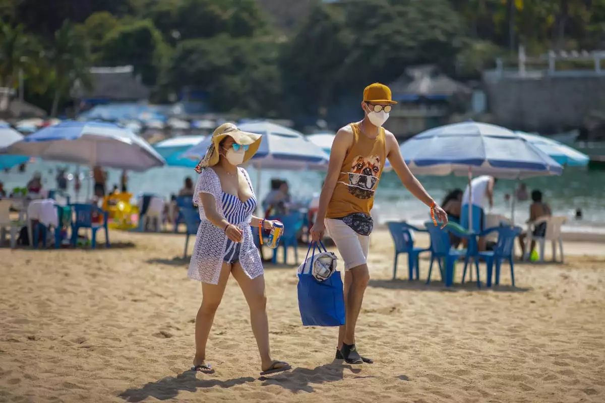 Estados Unidos pide a sus ciudadanos reconsiderar viajes a México por COVID (Turistas caminan por las playas de Acapuco)