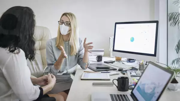 Businesswoman in medical mask explaining her idea