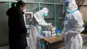 Un trabajador médico con traje protector registra información para un paciente en la entrada de la clínica de fiebre del Hospital Central de Wuhan, en medio del brote de la enfermedad por coronavirus (COVID-19), en Wuhan, provincia de Hubei, China, 31 de diciembre de 2022