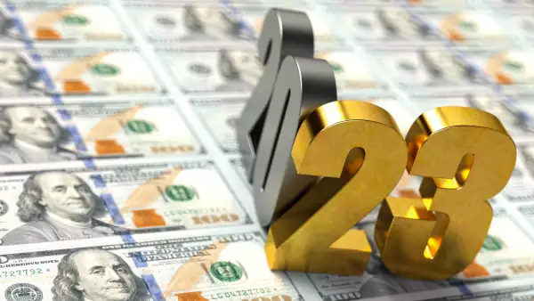 Gold Colored 2023 Sitting Over American Dollar Bills