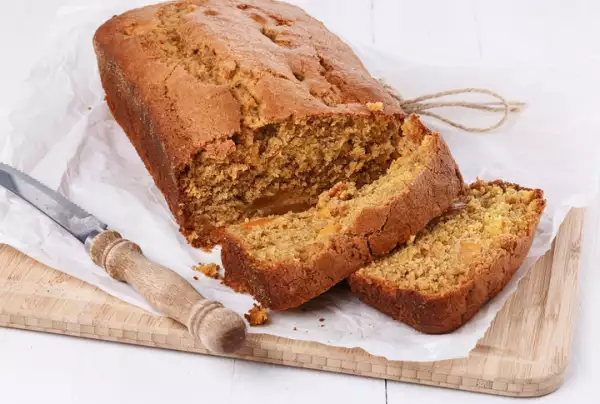 Pumpkin bread loaf over white wooden background