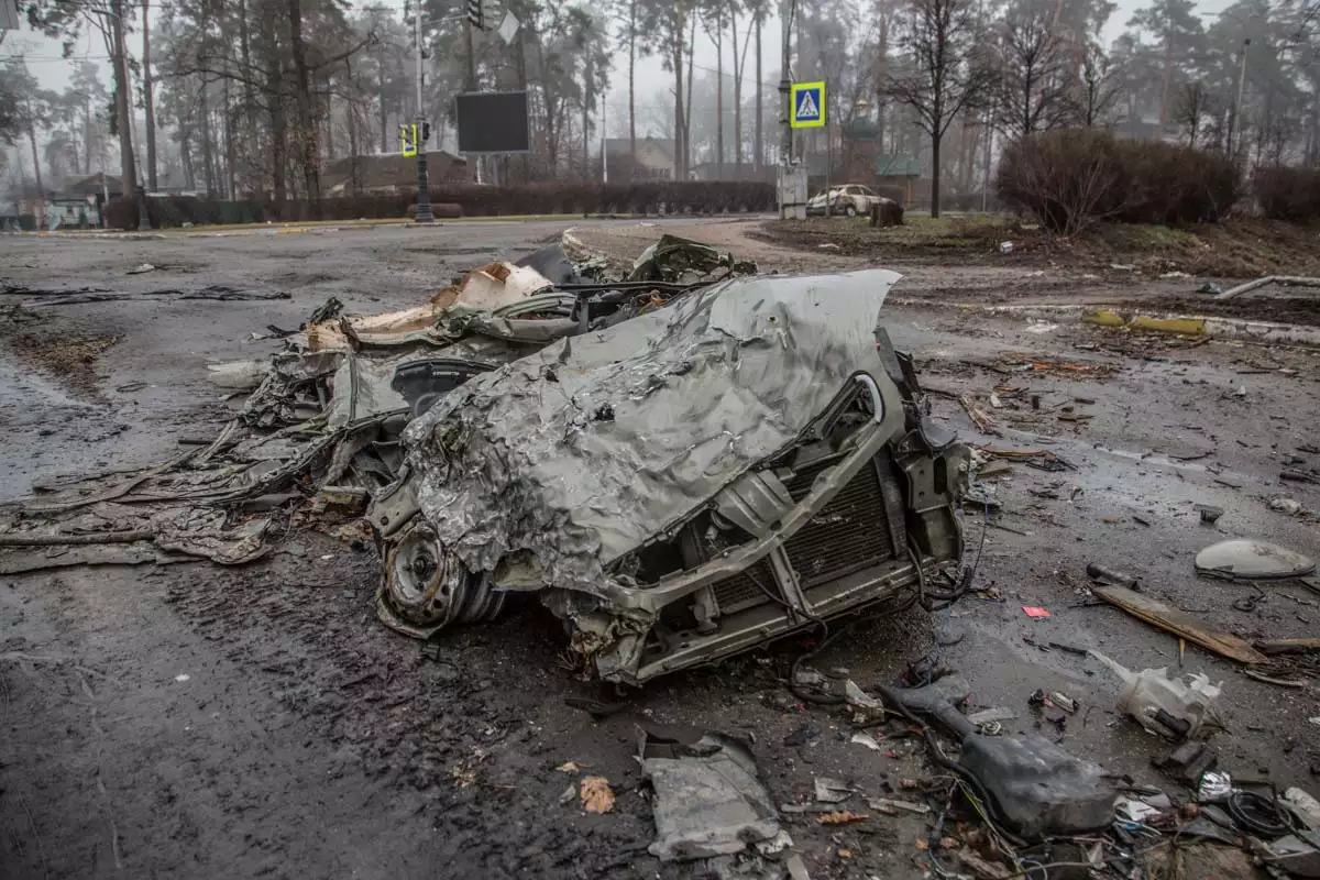 Autos aplastados en una calle vacía, mientras continúa el ataque de Rusia contra Ucrania, en la ciudad de Bucha.