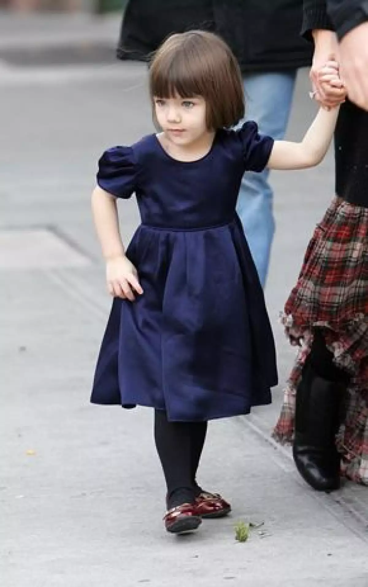 La hija de Tom y Katie se quita los pantalones cuando intentan ponérselos.