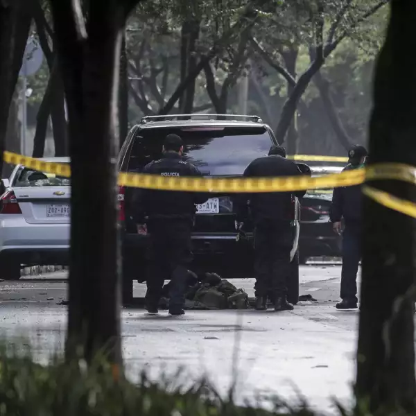 Police officers are seen near a vehicle after a shooting in Mexico City