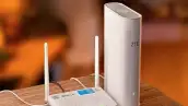 Dos moden uno con la marca de Megacable y otro de ZTE colocados en una mesa de madera color café.