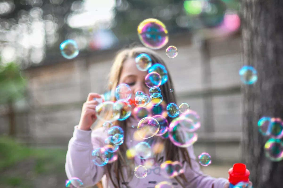 niña echando burbujas