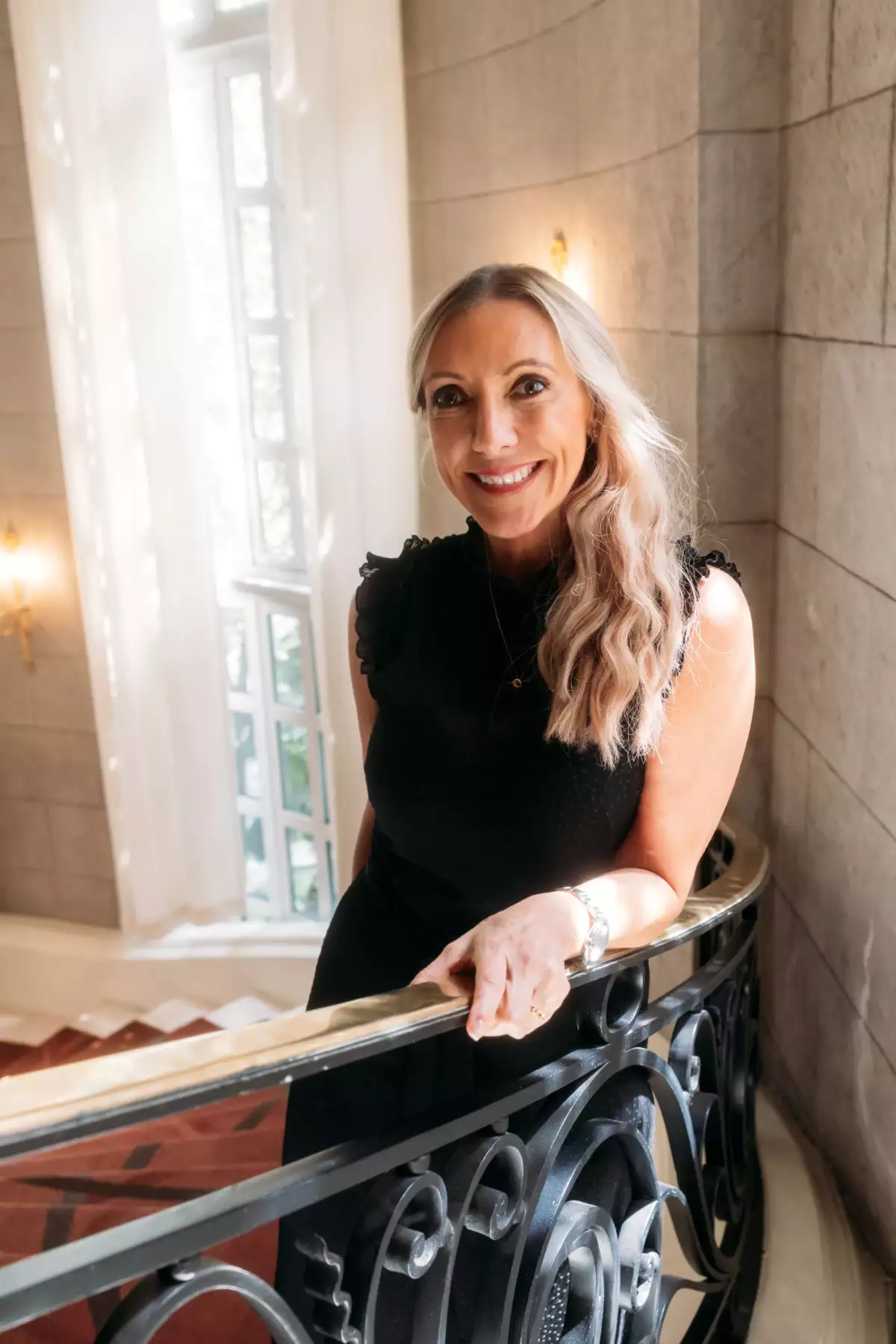 Mujer parada en unas escaleras sonriendo 
