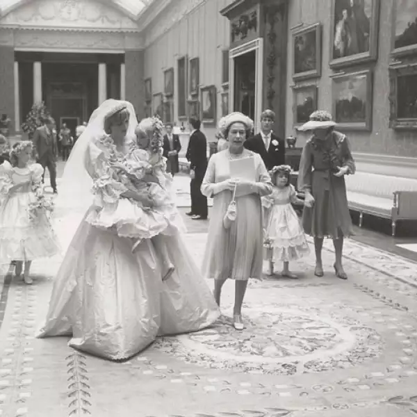 La princesa Diana fue captada por uno de sus familiars sosteniendo a su dama más pequeña, Clementine Hambro. La reina Isabel II aparece a su lado.