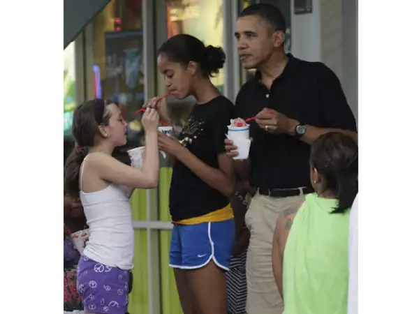Malia con una amiga y Barack disfrutando de un delicioso helado.