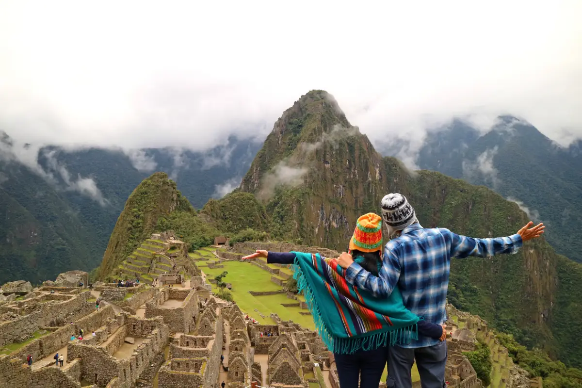 Pareja que admira la espectacular vista de Machu Picchu, región de Cusco, provincia de Urubamba, Perú, sitio arqueológico, patrimonio mundial de la UNESCO
