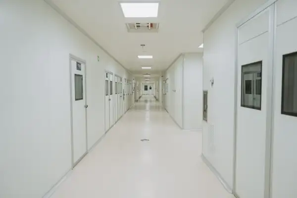 Pasillo que muestra a lo largo paredes y puertas en color blanco.