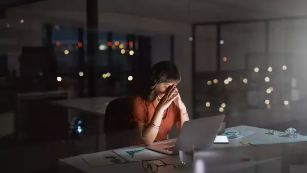 Los empleados infelices también son improductivos (Mujer trabajando en oficina de noche)
