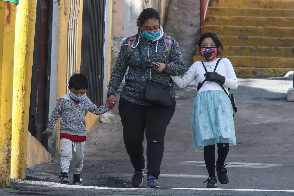 Mujer camina junto a sus dos hijos en las primeras horas del martes.
FOTO: ROGELIO MORALES /CUARTOSCURO.COM