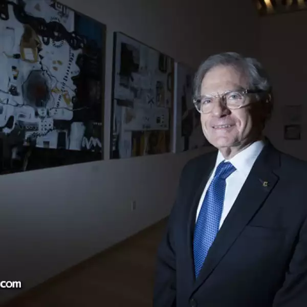 José Grinberg posa ante sus obras de técnica mixta.