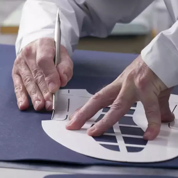 Un artesano de la firma corta a mano el cuero Saffiano -proviene de terneros criados en Italia con un proceso que lo protege de manchas y rayones-, utilizando un molde precortado. Posteriormente, s...