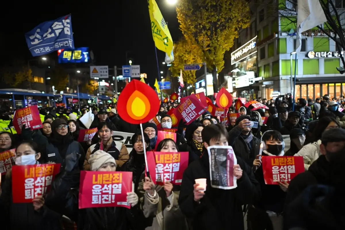 Los manifestantes que participan en una marcha contra el presidente de Corea del Sur, Yoon Suk Yeol, se dirigen a la Oficina Presidencial en Seúl el 4 de diciembre de 2024. Miles de manifestantes marcharon contra la oficina de Yoon en la capital surcoreana en la noche del 4 de diciembre, uniéndose al impulso de la oposición del país para destituir al líder después de su extraordinaria pero efímera imposición de la ley marcial.