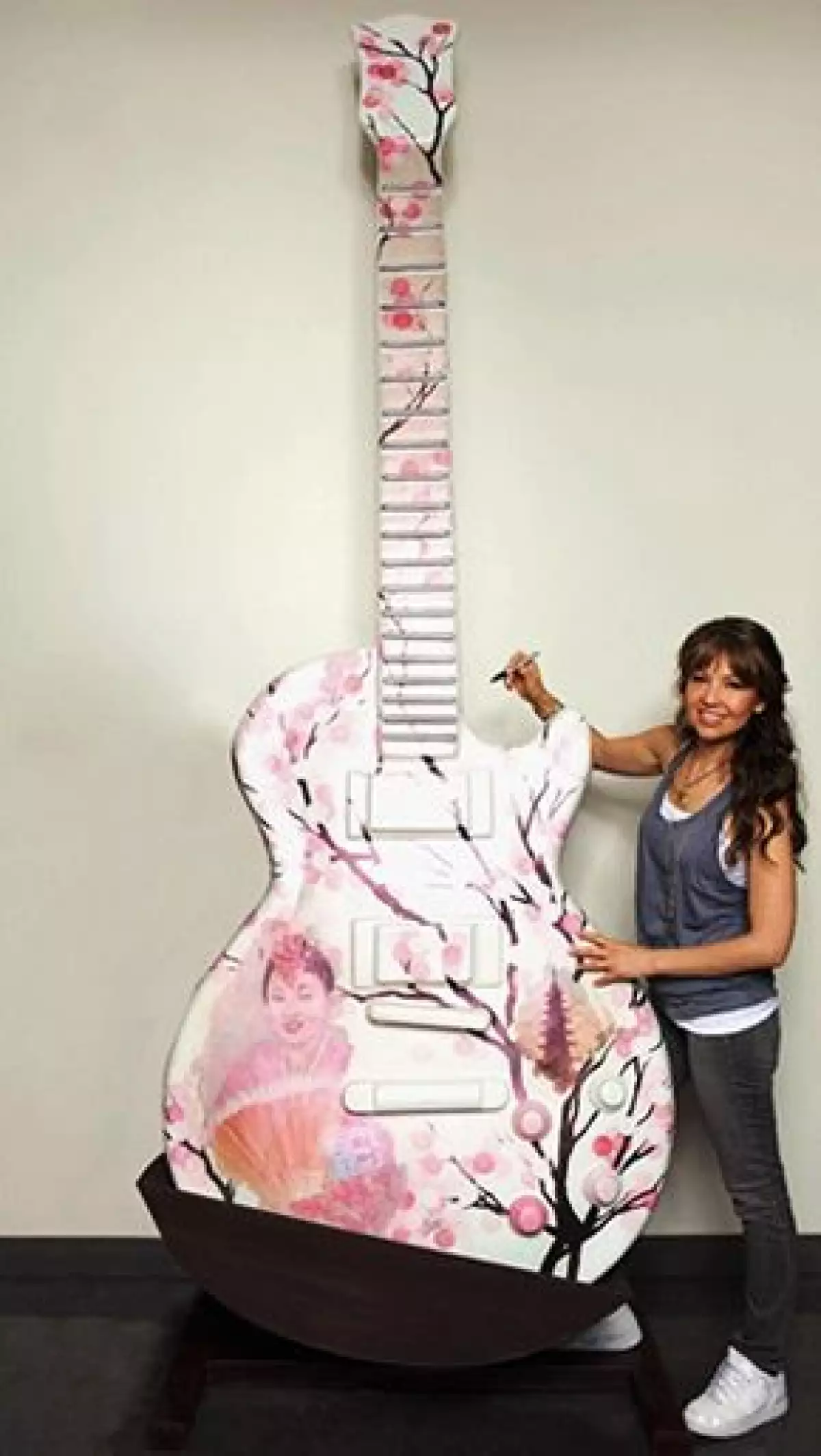 La cantante y actriz mexicana Thalía se une a la exposición de Miami GuitarTown al firmar una de las
esculturas en forma de guitarra Gibson Les Paul, de 10 pies de altura.