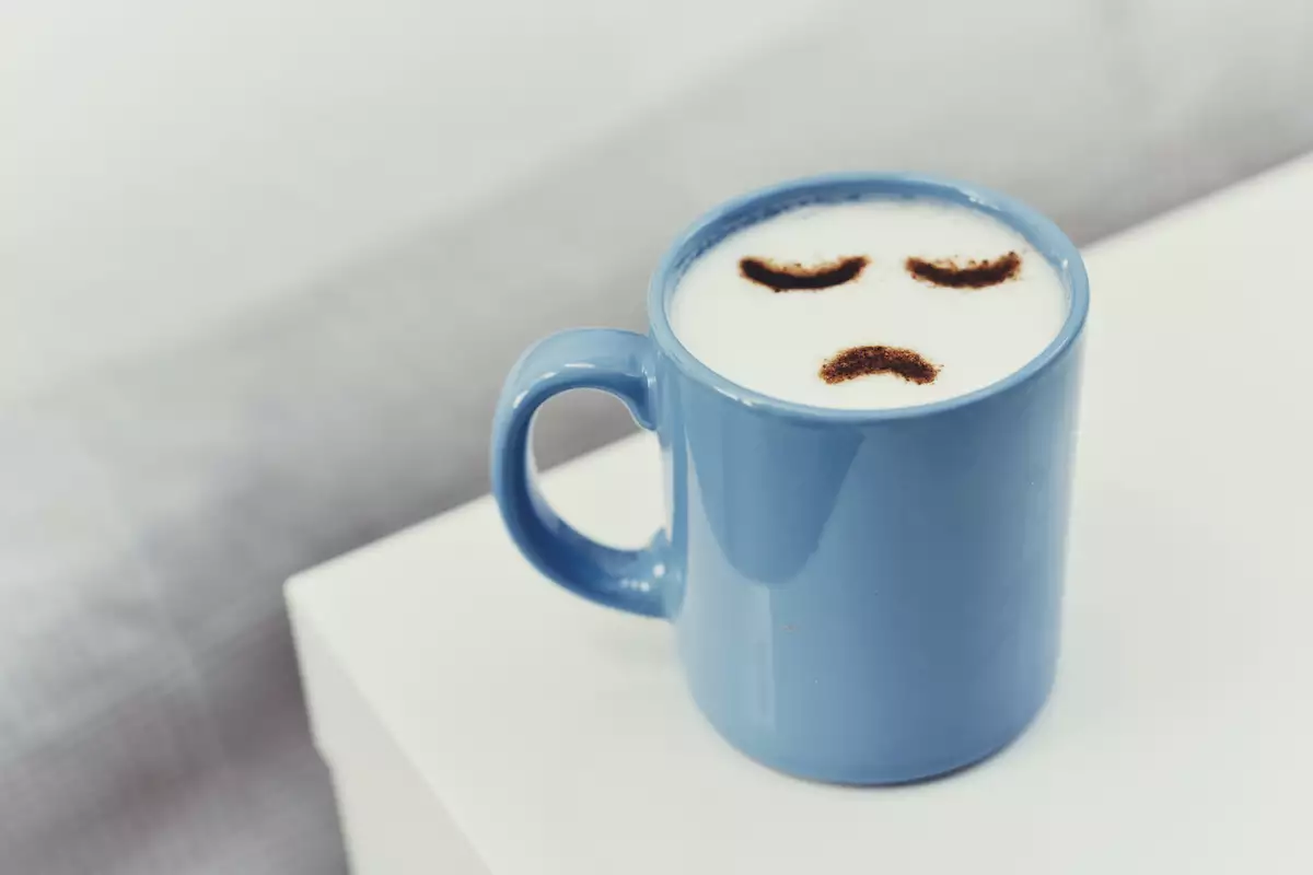 cup of cappuccino with a sad face