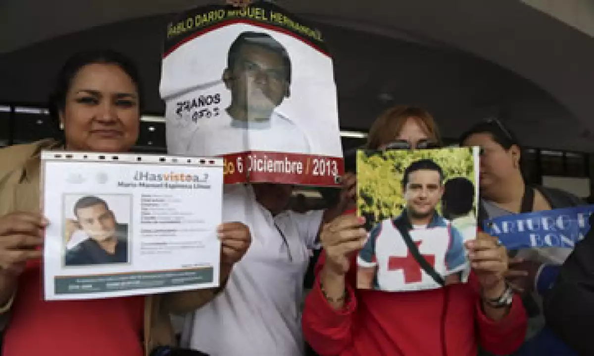 Familiares de los jóvenes desaparecidos muestran fotos de sus seres queridos durante una protesta en Veracruz. (Foto: Cuartoscuro )