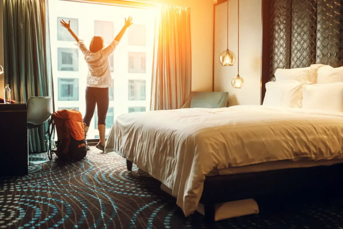 persona feliz en la habitación de un hotel