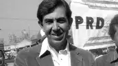 Foto de Cuauhtémoc Cárdenas de joven, con camisa blanca y saco oscuro, durante un acto político del PRD.