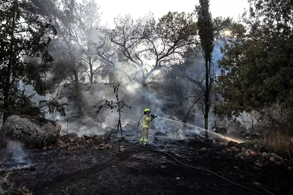 Un bombero trabaja después de que Hezbollah del Líbano dijera que lanzó más de 200 cohetes y un enjambre de drones contra sitios militares israelíes, cerca de la frontera entre Israel y el Líbano en el lado israelí el 4 de julio de 2024. ISRAEL FUERA.