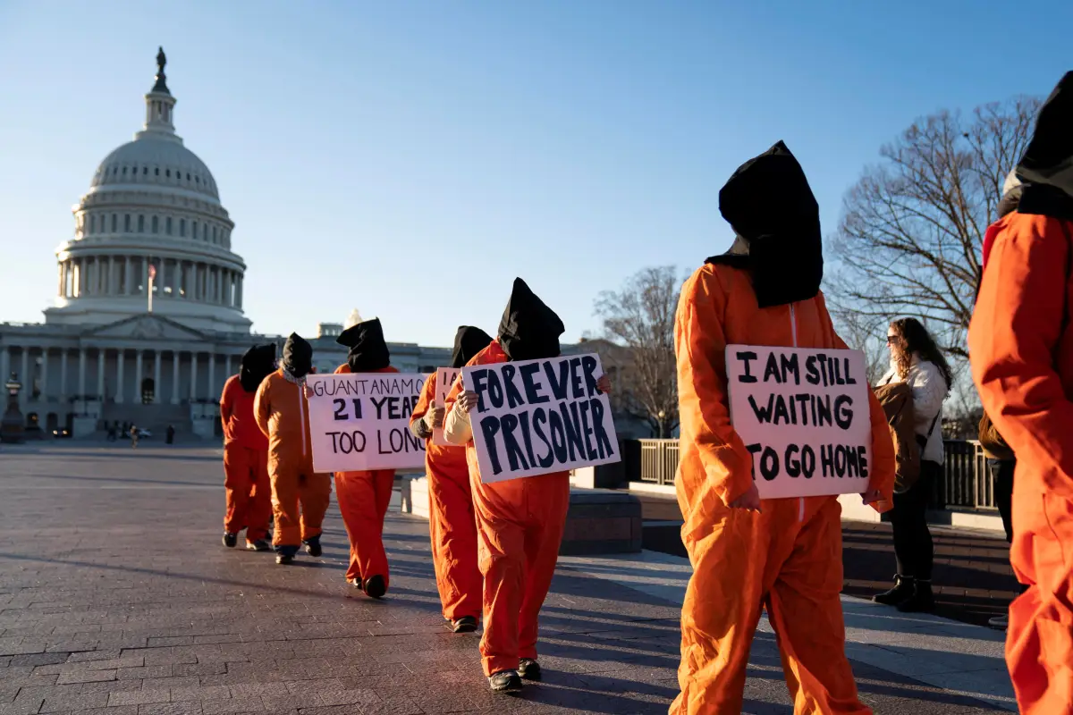 Un grupo de personas vestidas de prisioneros protestan contra el Campo de Detención de la Bahía de Guantánamo fuera del Capitolio de los Estados Unidos en Washington, D.C., EE. UU., 9 de enero de 2023. (Imagen principal del artículo 'De prisioneros de guerra a migrantes: Guantánamo reabre como centro de detención')