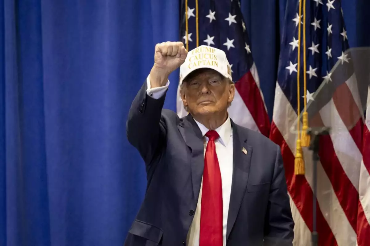 El expresidente de los Estados Unidos y candidato presidencial republicano de 2024, Donald Trump, levanta el puño en un evento de Commit to Caucus en el Simpson College en Indianola, Iowa, el 14 de enero de 2024.