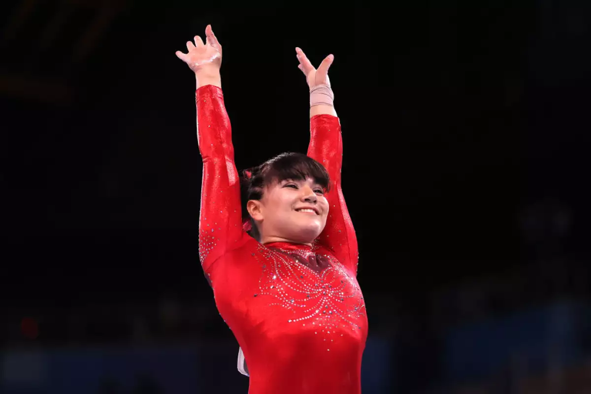 foto de la gimnasta alexa moreno sonriendo; viste con leotardo rojo y los brazos levantados