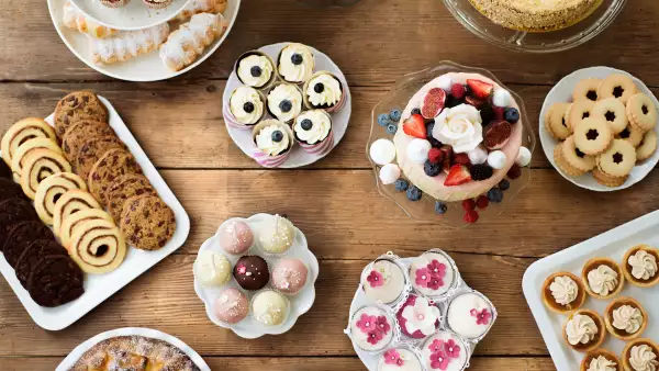 Table with cakes, cookies, cupcakes, tarts and cakepops.