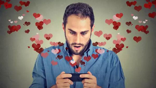 young handsome shocked man sending receiving love sms