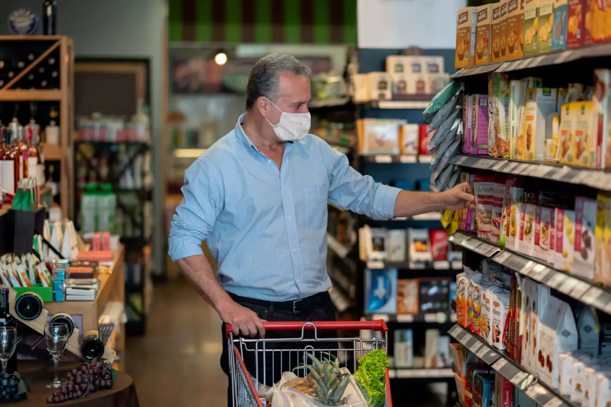 Un hombre hace compras de alimentos en un súpermercado. 