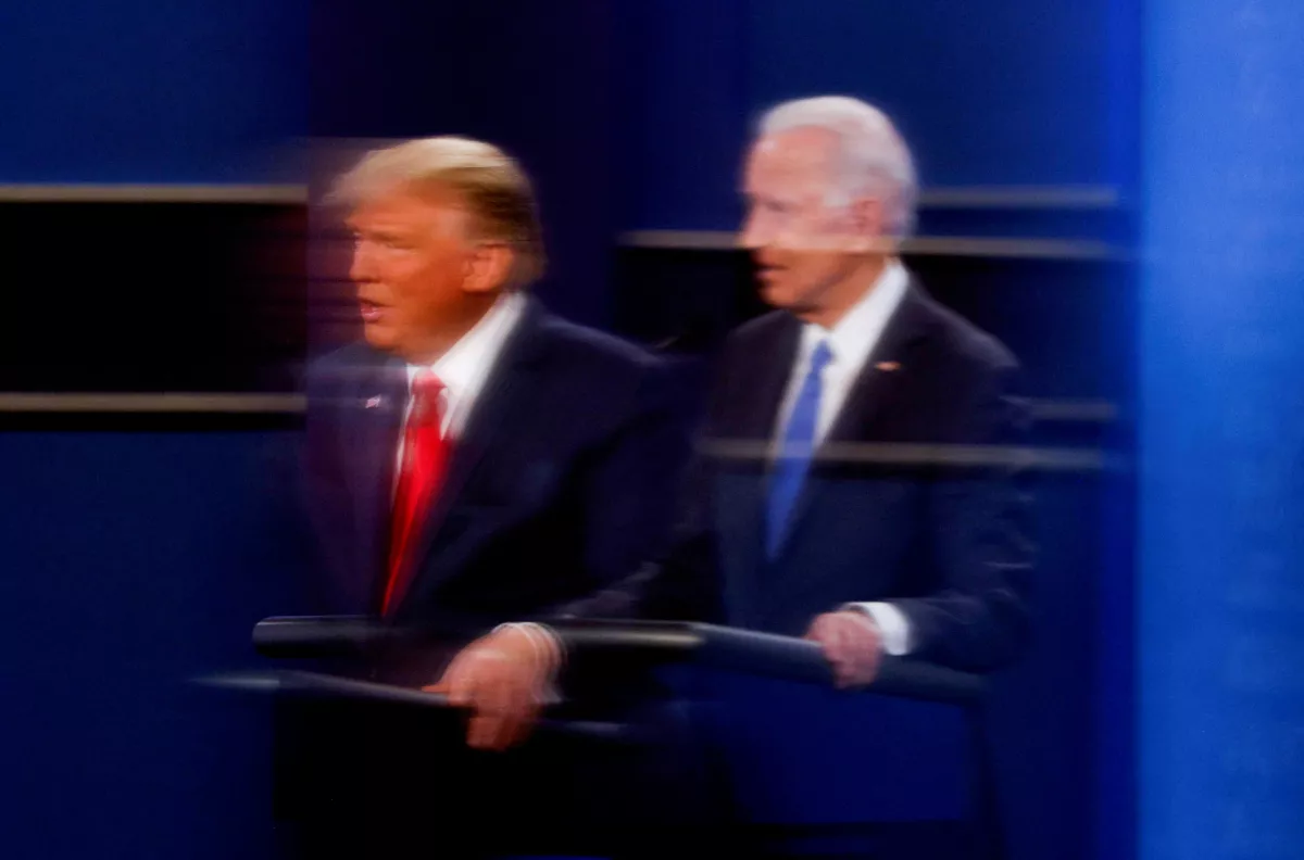 El presidente de los Estados Unidos, Donald Trump, y el candidato presidencial demócrata Joe Biden, se reflejan en el plexiglás que protege a un operador de cámara de televisión del coronavirus mientras participan en su segundo debate de campaña presidencial de 2020 en la Universidad de Belmont en Nashville, Tennessee, EE. UU., el 22 de octubre de 2020.