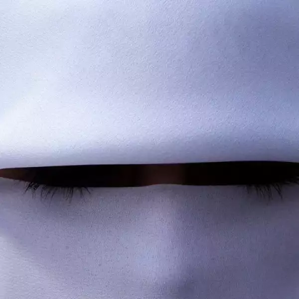 Unas largas pestañas sobresalen del velo impecablemente blanco de esta mujer jordana.