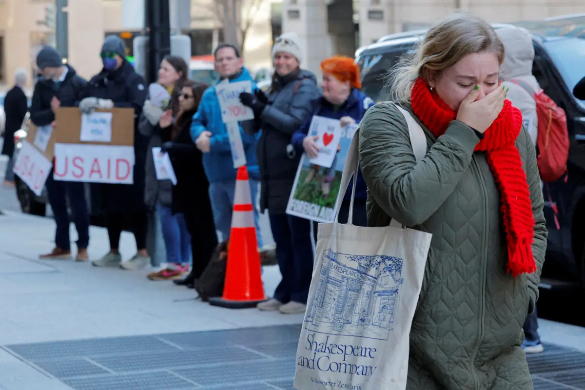 Un miembro del personal de la Agencia de los Estados Unidos para el Desarrollo Internacional (USAID) recientemente despedido reacciona mientras abandona el trabajo, durante una despedida de ex empleados y partidarios de USAID fuera de las oficinas de USAID en Washington, D.C., EE. UU., el 21 de febrero de 2025.