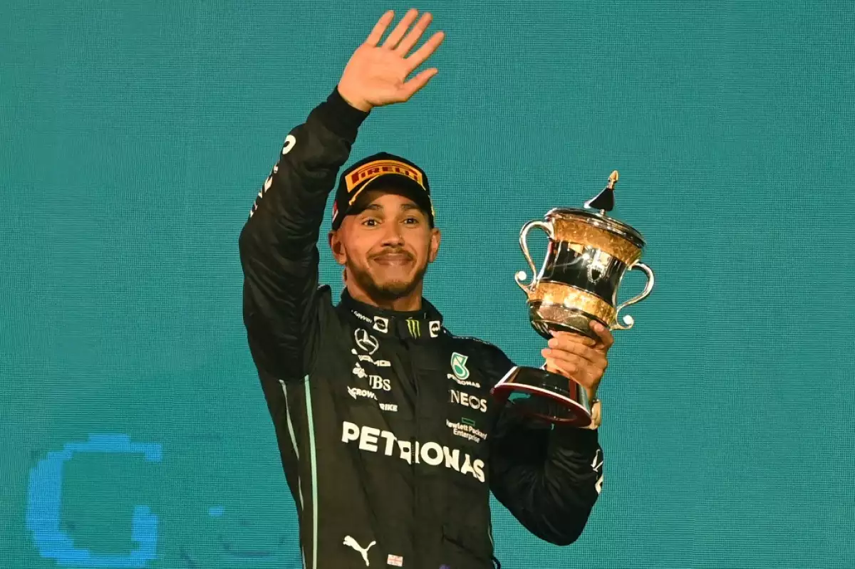 Foto de Lewis Hamilton en marzo de 2022 cargando el trofeo del tercer lugar en el Grand Prix de Bahrain de la Fórmula 1.
