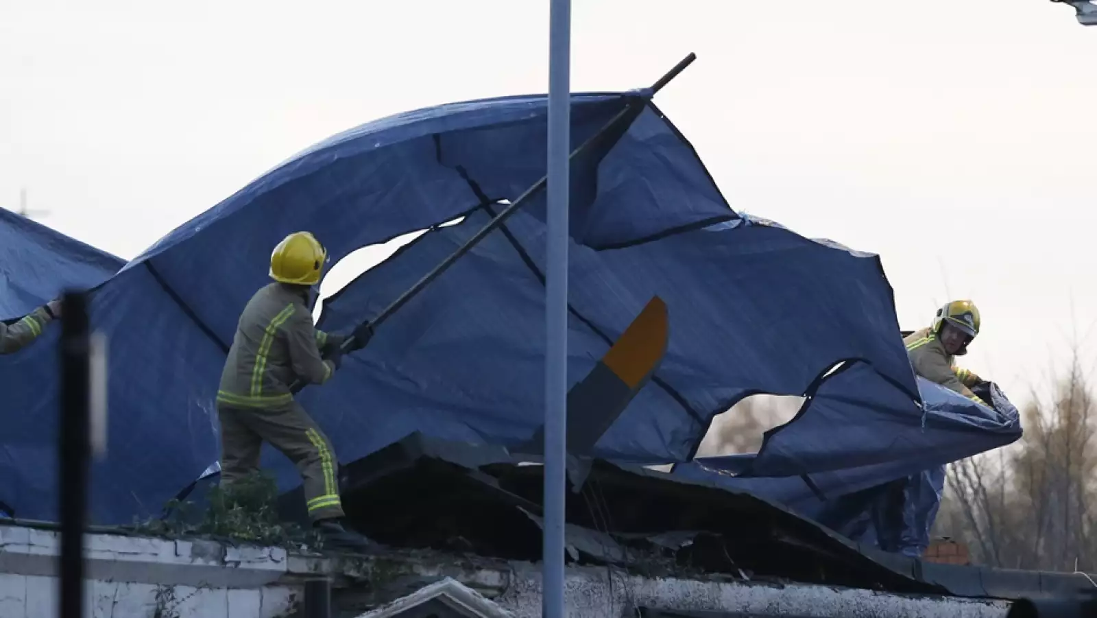 bomberos cubren los restos del helicoptero