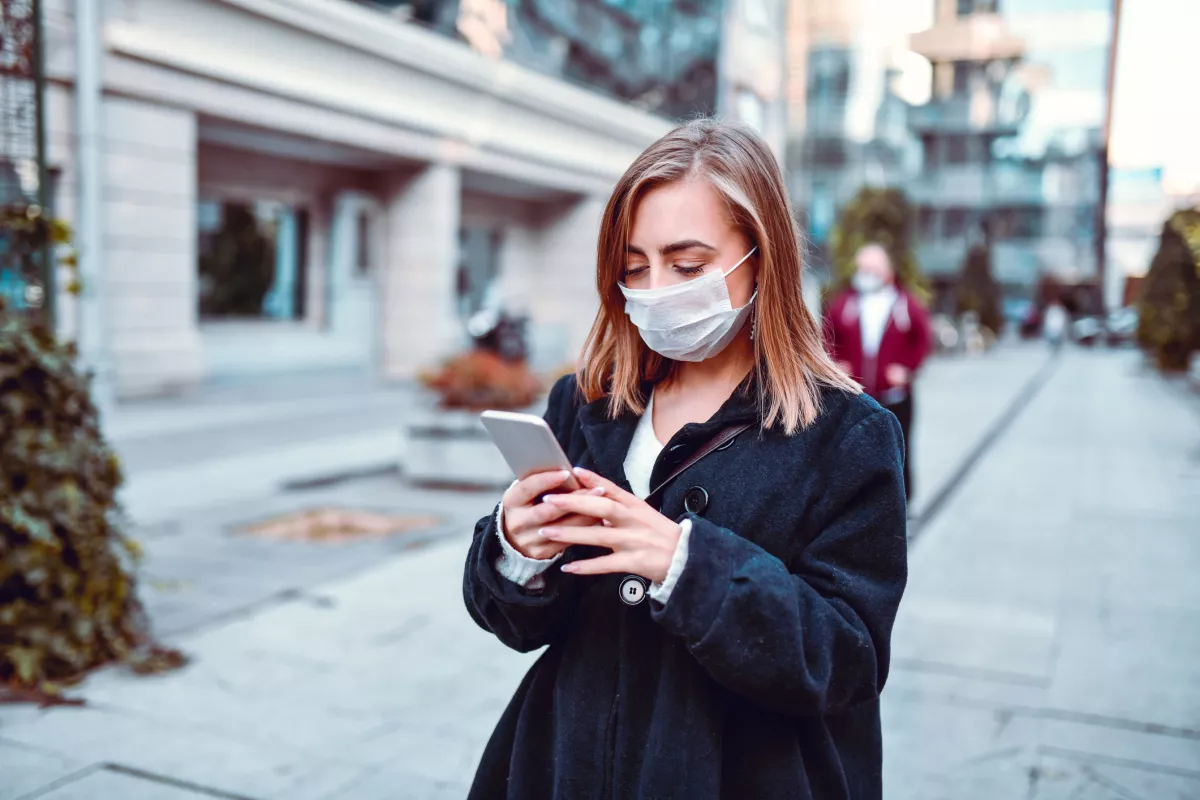Female Finding Her Way On GPS While Wearing Anti Air Pollution Mask