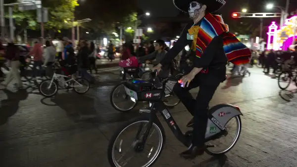 hombre vestido de charro pasea en una bici de Ecobici durante el Paseo Nocturno de Dia de Muertos 2026