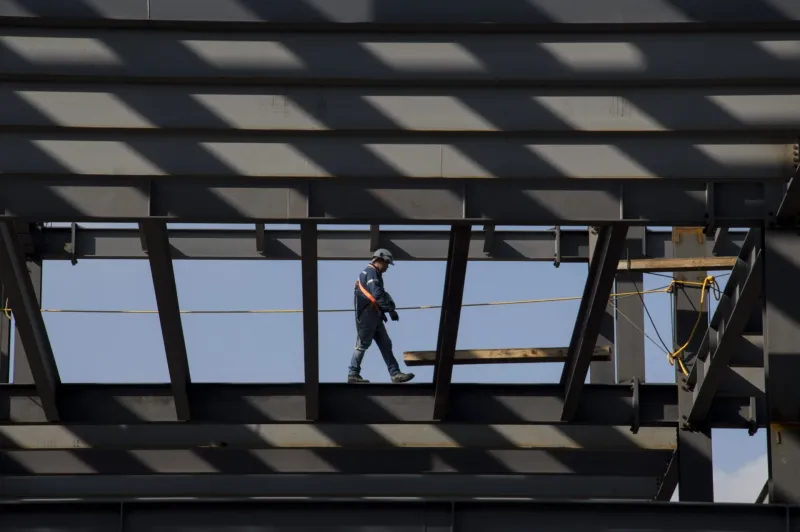 En la imagen, un trabajador camina por las trabes de la construcción de un edificio frente al Centro Cultural Universitario de Tlatelolco.