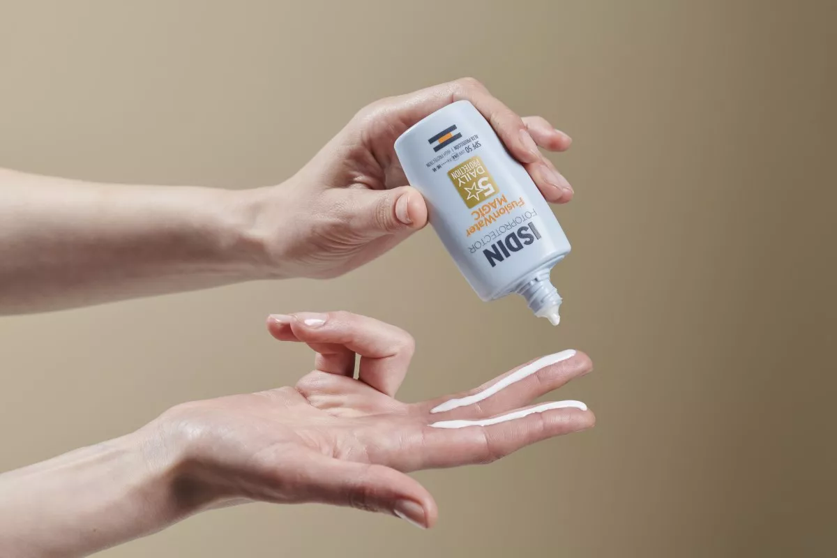 Se muestran las anos de una persona que está utilizando el bloqueador de rostro Fusion Water MAGIC Oil Control SPF 50, que te ofrece hasta 12 horas de hidratación tras un solo uso.