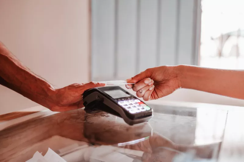 Una persona paga su tarjeta.
