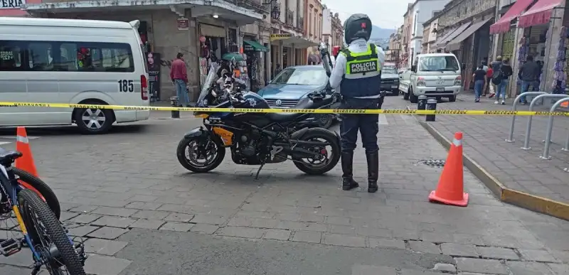 Policía municipal de Morelia junto a su motocicleta cierra la circulación vial. 