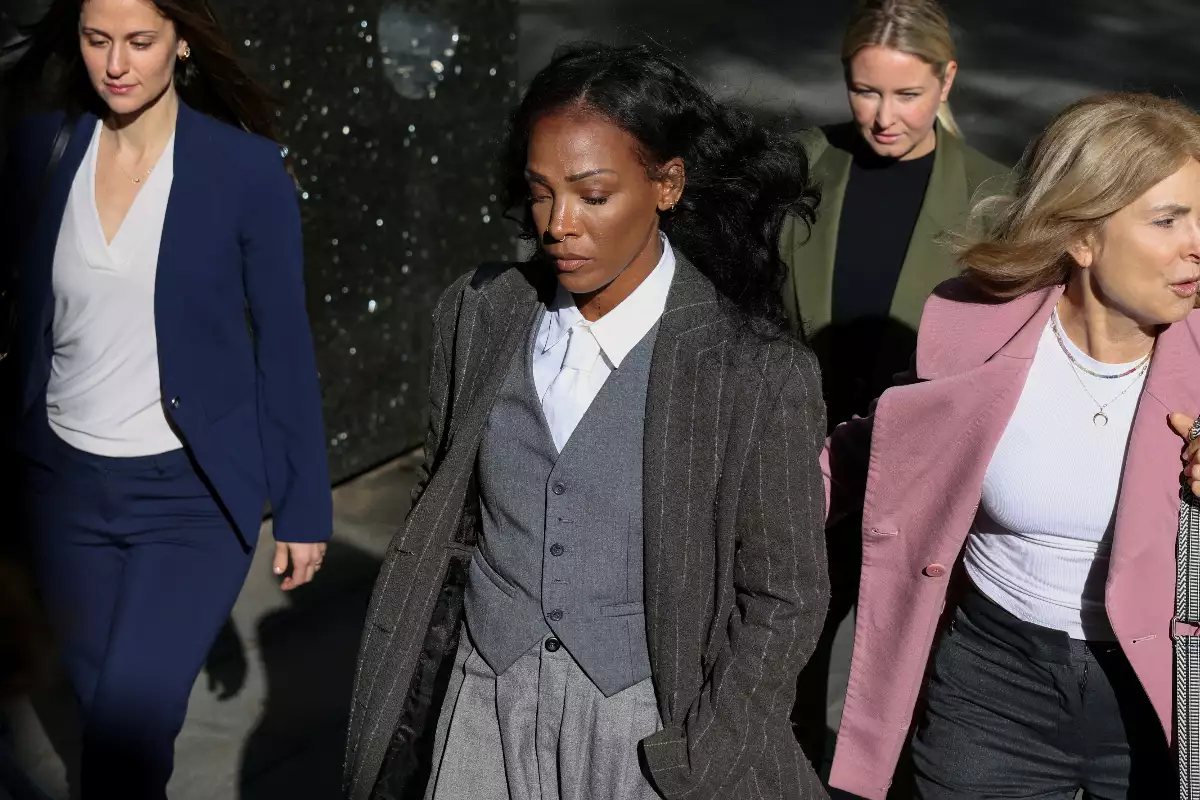 Foto de Dawn Richard, vestida de abrigo y traje sastre gris, llegando a la corte de Nueva York para declarar contra Sean Diddy Combs.