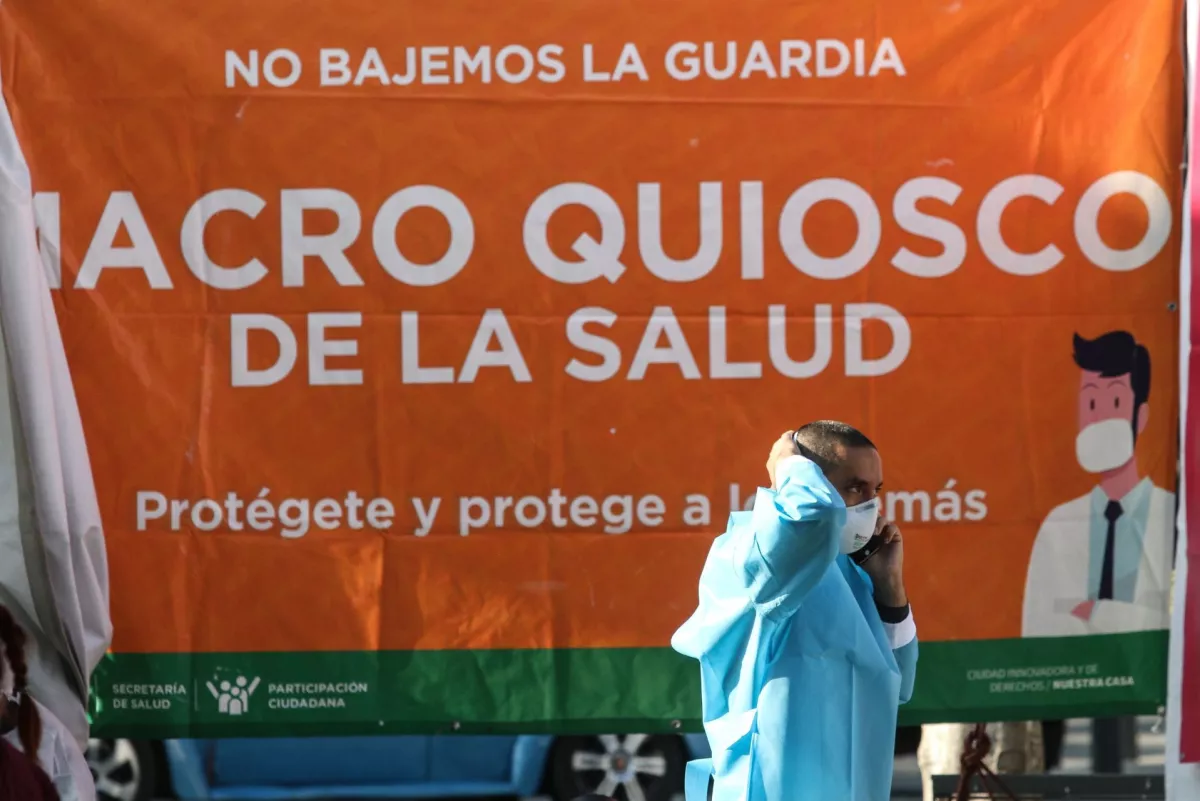 Un médico realiza una llamada frentea lona del Macro Quisco COVID-19 en la plaza de Etiopía.